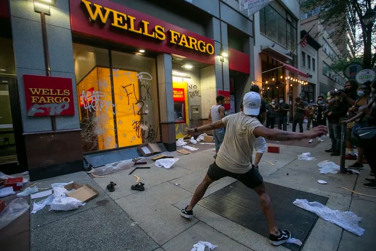 A vandal repeatedly threw rocks at the front of the Wells Fargo on Walnut St in the Rittenhouse square area. Looters took to the streets of Center City Philadelphia during a protest against the death of George Floyd by police in Minneapolis, Minnesota. Photograph from Saturday, May 30, 2020.