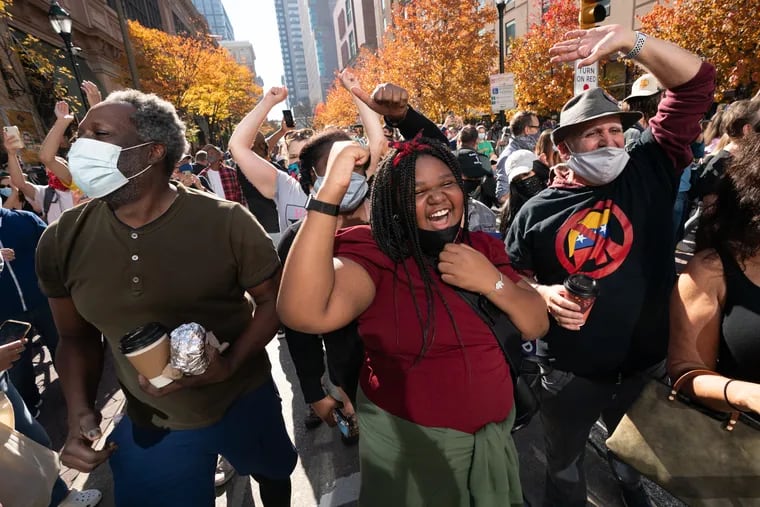 Laila Williamson (center) cheers with others as people gather outside of the Pennsylvania Convention Center on Saturday after the Associated Press called the presidential election for Joe Biden.