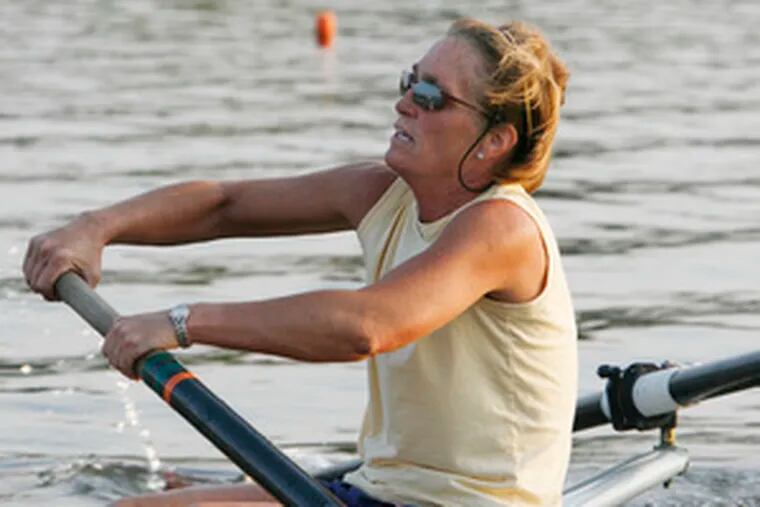 Getting a strenuous workout, Julie Close, 50, of Moorestown, moves along the Cooper River with fellow master rowers.