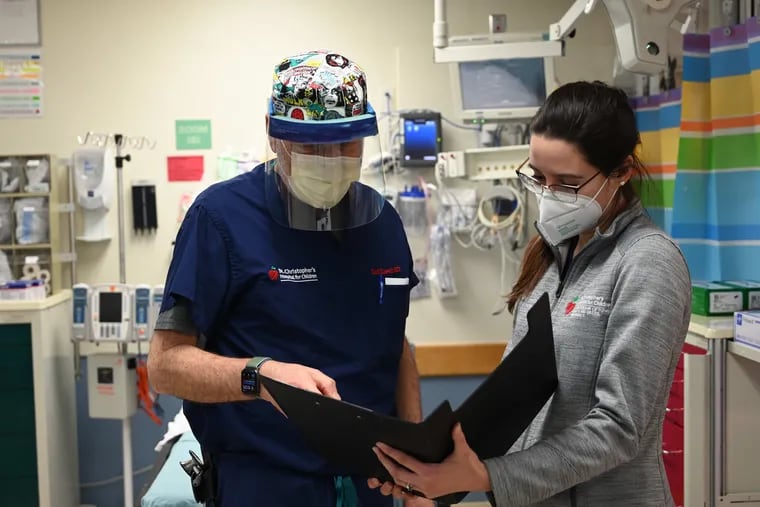 Zach Kassutto, left, medical director of the emergency department at St. Christopher's Hospital for Children, had seen no cases of the flu this winter as of Jan. 17. He is speaking with emergency medicine fellow Valeria Diaz Fragachan.