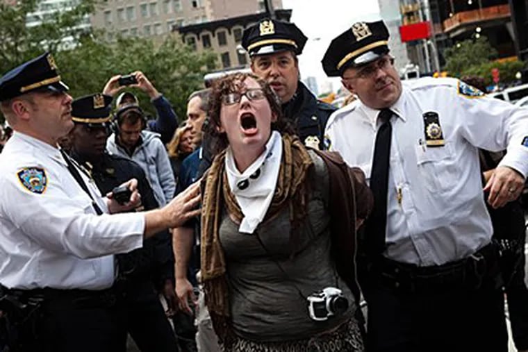 Occupy Wall Street protester Alexi Morris is arrested Monday in the financial district's Zucotti park in New York. (AP Photo/John Minchillo)