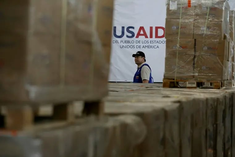 A man walks past boxes of USAID humanitarian aid at a warehouse at the Tienditas International Brigde on the outskirts of Cucuta, Colombia, Thursday, Feb. 21, 2019, on the border with Venezuela. Venezuela's President Nicolas Maduro said he’s weighing whether to shut down the border with Colombia, where the bulk of aid meant for Venezuela is being stockpiled and exiled leaders have been gathering ahead of a fundraising concert Friday. (AP Photo/Fernando Vergara)