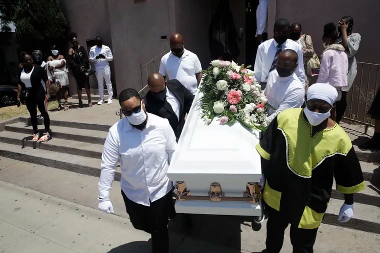 In this July 21 photo, pall bearers carry a casket with the body of Lydia Nunez, who died from COVID-19, after a funeral service at the Metropolitan Baptist Church in Los Angeles.