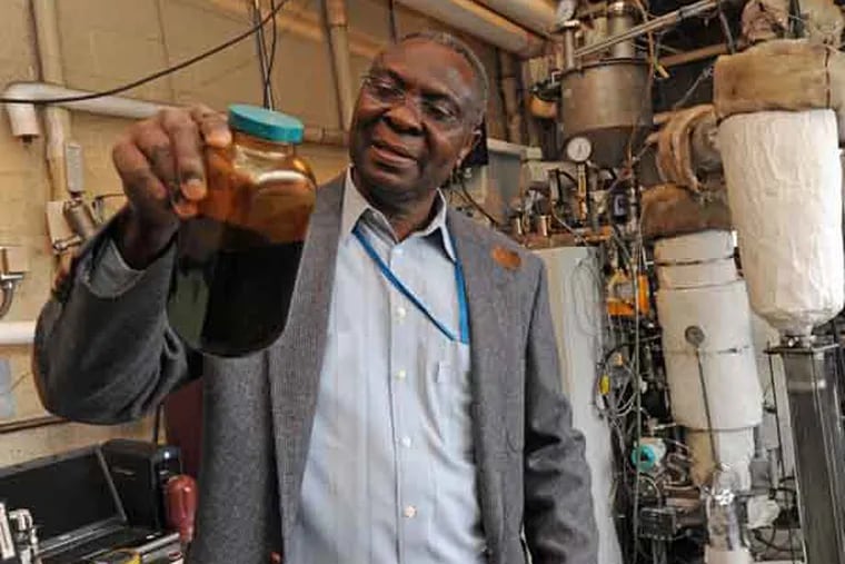 The pyrolysis machine at the research arm of the USDA at its center in Wyndmoor, PA on Jan. 15, 2013. Here, Akwasi A. Boateng holds up a sample of oil produced by the process.  APRIL SAUL / Staff Photographer