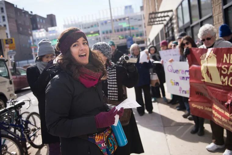 Belle Alvarez, a member of New Sanctuary Movement of Philadelphia, leads a song outside the Center City offices of ICE at a Feb. 13 protest that played a role in the dismissal of three staff organizers.