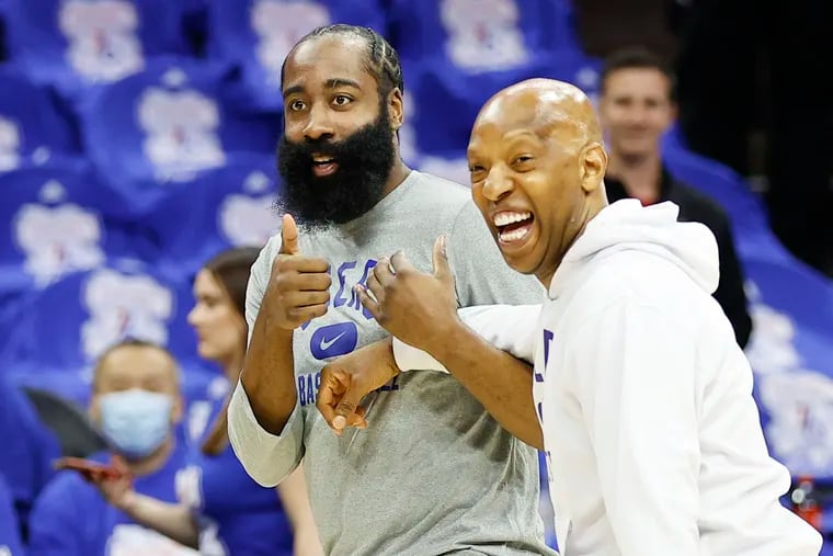 Sixers guard James Harden has a laugh with assistant coach Sam Cassell during warm-ups before a game against the Toronto Raptors.