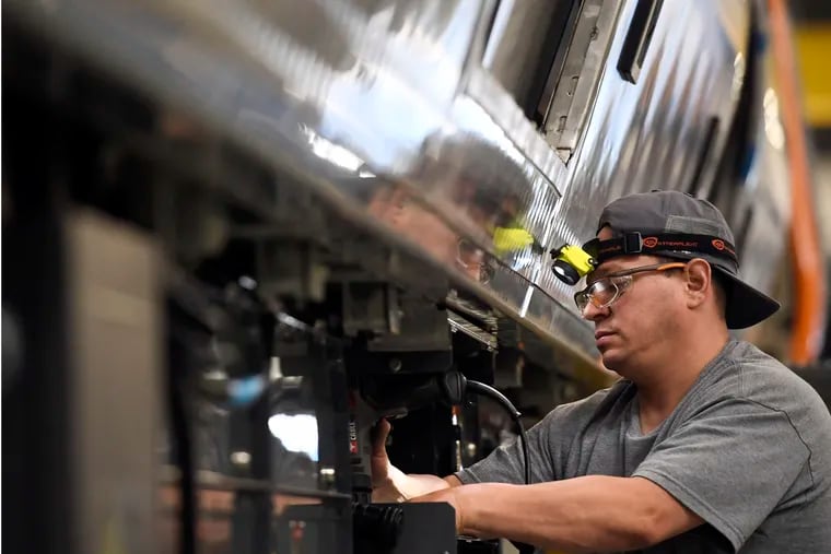 Felix Santos works on a rail car for Boston's Orange and Red Line T fleets at CRRC in 2019 in Springfield, Mass. SEPTA has “terminated for cause” a contract with the China Railway Rolling Stock Corp. that was supposed to add 45 double-decker commuter rail cars to the agency's fleet.