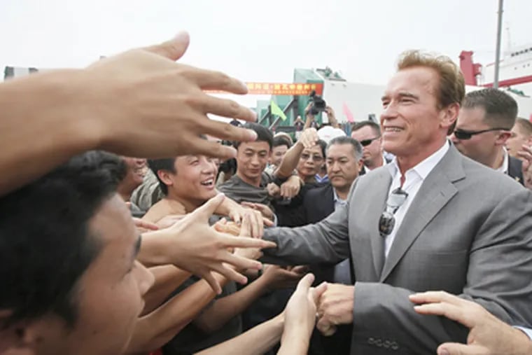 California's then-governor, Arnold Schwarzenegger (top), greets
workers in Shanghai. (Eugene Hoshiko / Associated Press)