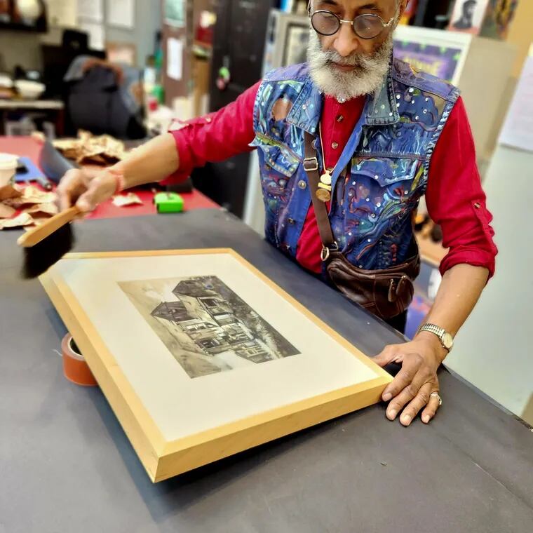 Richard Watson, an artist in residence and exhibits manager with the African American Museum in Philadelphia, prepares one of Dox Thrash's works for the new exhibit.