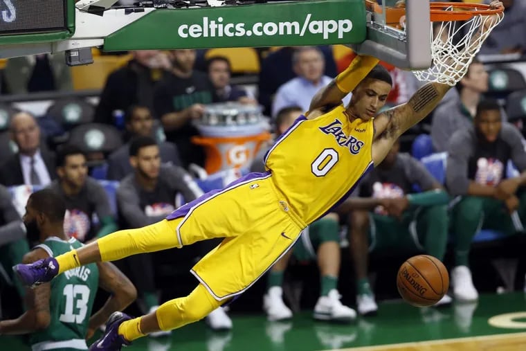 Los Angeles Lakers forward Kyle Kuzma swings from the rim after dunking against the Boston Celtics during the third quarter of Boston's 107-96 win in an NBA basketball game in Boston Wednesday, Nov. 8, 2017. (AP Photo/Winslow Townson)