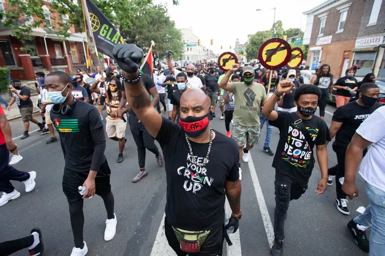 On Friday, black men marched in the Brotherly Love Juneteenth Silent March 2020, starting at 52nd Street and Girard Avenue and ending at Malcolm X Park. At the park, the men took off their masks, which featured words like 'fear,' 'anger,' and 'lies' and let out a cry to release their pain. Kyle “The Conductor” Morris, (center) one of the organizers, marches with the word 'fear' on his mask.