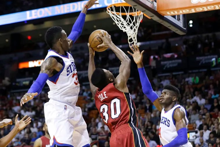 Rookie Nerlens Noel (right), getting help here from teammate Robert Covington on the Heat’s Norris Cole, has helped the Sixers’ defense improve from the worst last year to the 11th-best this year. (Lynne Sladky/Associated Press)