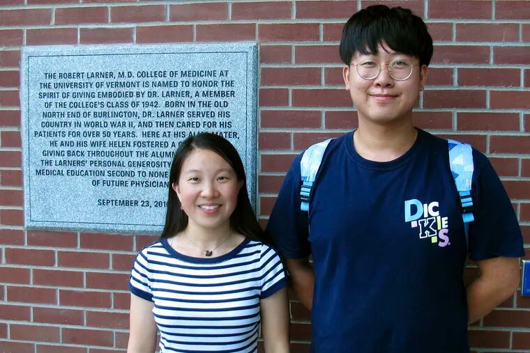 In this photo Aug. 16, 2019, photo, Chinese graduate students Zhaojin Li, left, and Pengfei Liu, pose in front of the entrance to the Robert Larner College of Medicine at the University of Vermont in Burlington, Vt. Some higher education officials are concerned by a drop in the number of international students coming to the United States, especially from China. Li and Liu say that some of their relatives were concerned for their safety in coming to the United States, but they are too busy with their studies to focus on geopolitical issues. (AP Photo/Wilson Ring)