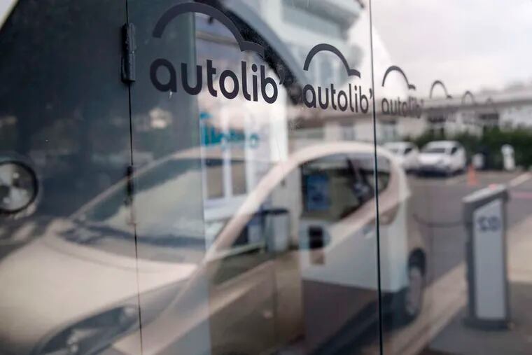 The Autolib logo at a charging station at the car-sharing company's headquarters in Vaucresson, France. Vincent Bollore, chairman of the Bollore Group, is targeting Los Angeles and Singapore as the next markets for his electric-car sharing service after its debuts this year in London and Indianapolis.