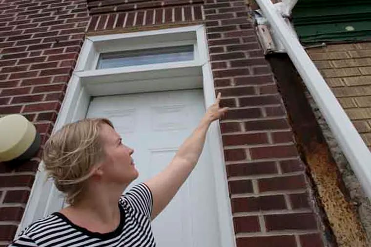 Heather Evans of 1000 block of E. Passyunk Ave in Philadelphia points to the makeshift repair of house next door.  ( ALEJANDRO A. ALVAREZ / PHILADELPHIA DAILY NEWS )