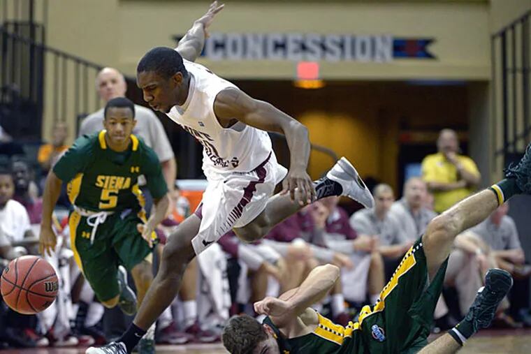Saint Joseph's guard Langston Galloway, center, steals the ball from Siena guard Rob Poole, below, as Evan Hymes watches during the first half of an NCAA college basketball game at the Old Spice Classic tournament in Kissimmee, Fla., Friday, Nov. 29, 2013. (AP Photo/Phelan M. Ebenhack)