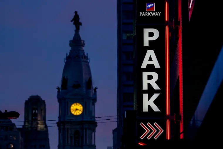 Sign for parking garage on North Broad Street with Philadelphia City Hall in background Mar. 14, 2022.