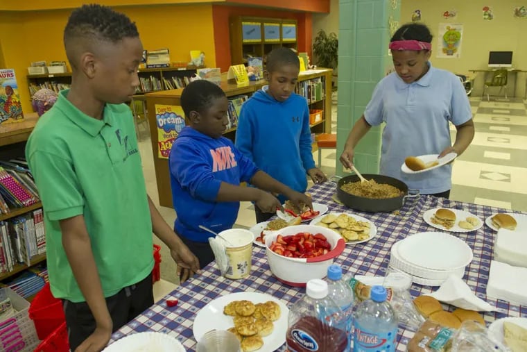 Prince Hall students (from left) Hakeim Smith, 11; Jordan Francis, 9; Samir Norris, 9; and Alia Miles, 11, serve the meal of sloppy joes and strawberry shortcake they prepared.