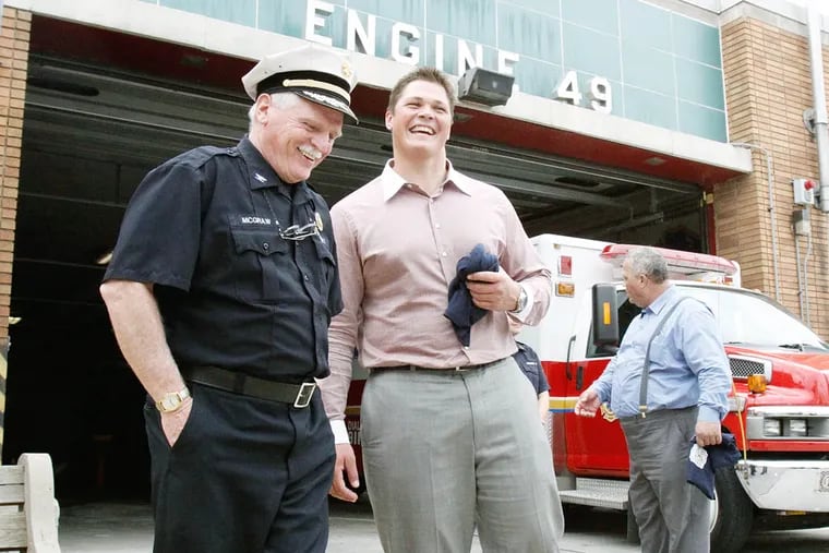 First-round pick Danny Watkins meets with Deputy Chief Joe McGraw during a visit to Engine 49. (ELIZABETH ROBERTSON / Staff photographer)