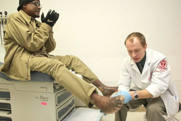 Dr. Andrew Meyr (CQ), right, a podiatrist in Temple University Hospital's Limb Salvage Center, treats patient, Tyrone Barnett, left, who suffers from numbness in the feet and hardenening of the arteries in the legs. ( Charles Fox / Staff Photographer )