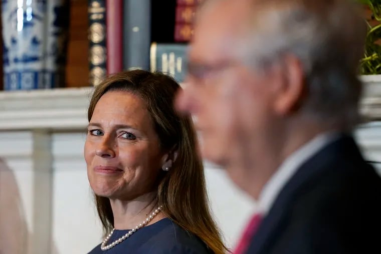 Supreme Court nominee Judge Amy Coney Barrett looks over to Senate Majority Leader Mitch McConnell on Capitol Hill in Washington.