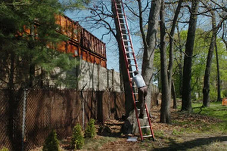 Steve Thomas of Hainesport monitors the waste transfer station from a 30-foot ladder in his yard. The site has been exempt from local environmental regulations, but that may soon change.