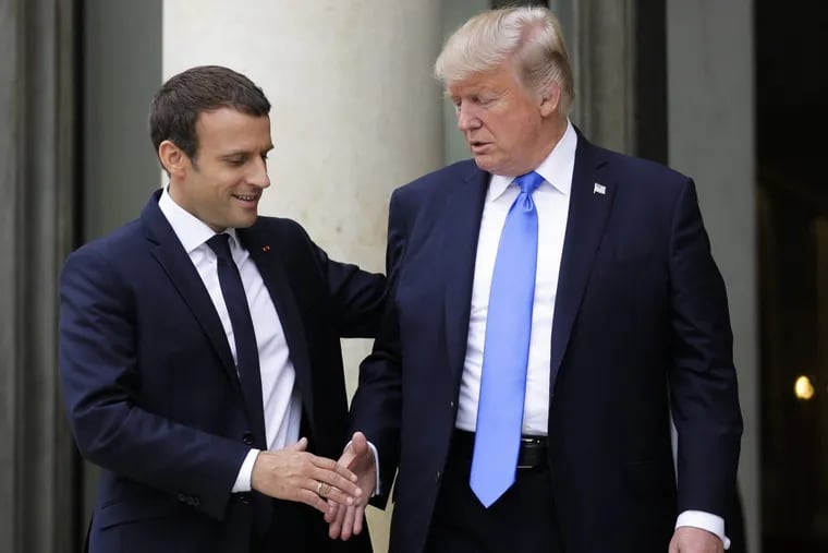 French President Emmanuel Macron welcomes President Trump before their meeting at the Elysee Palace in Paris on Thursday,