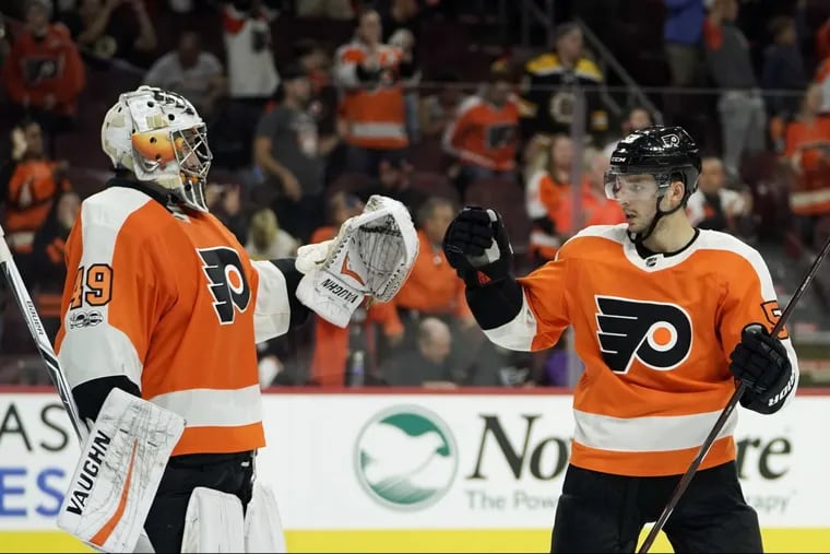 Flyers’ Alex Lyon, left, and Shayne Gostisbehere celebrate after a preseason game against the Bruins on Thursday.