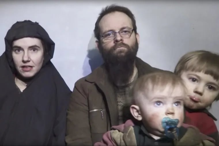 In this image from video released by Taliban Media in December 2016, Caitlan Coleman speaks while her husband, Joshua Boyle, holds two of their children.