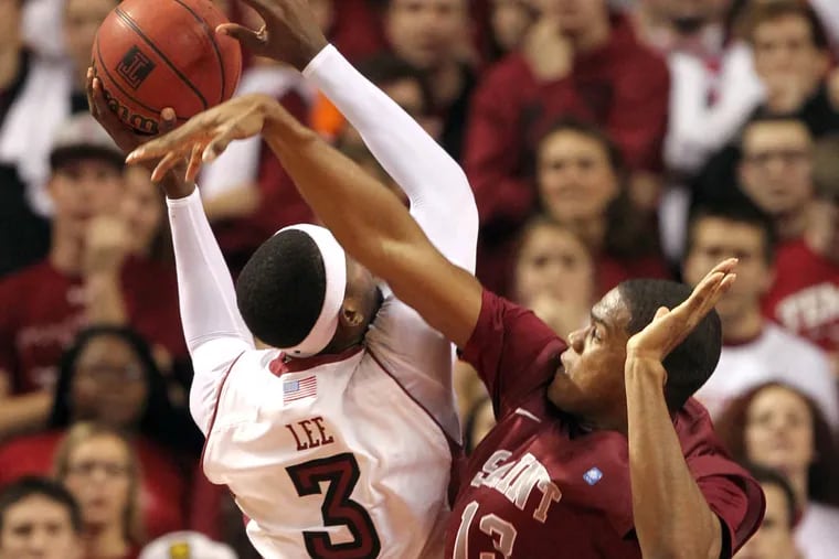 Saint Joseph's Ronald Roberts fouls Temple's Anthony Lee in the first half.