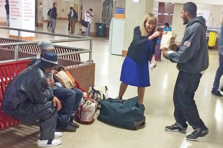 Sharon Suleta brings meals and socks to the homeless in the Suburban Station underground concourse.