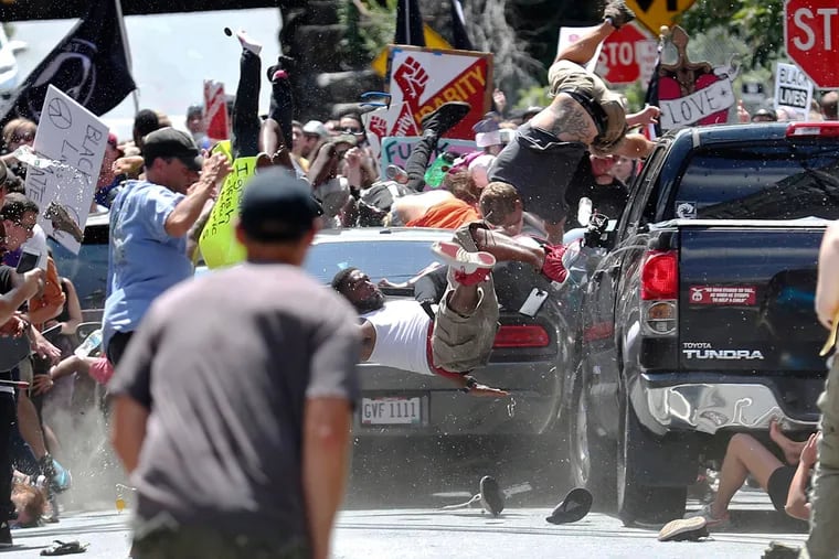 People fly into the air as a vehicle drives into a group of protesters demonstrating against a white nationalist rally in Charlottesville, Va., Saturday, Aug. 12, 2017.