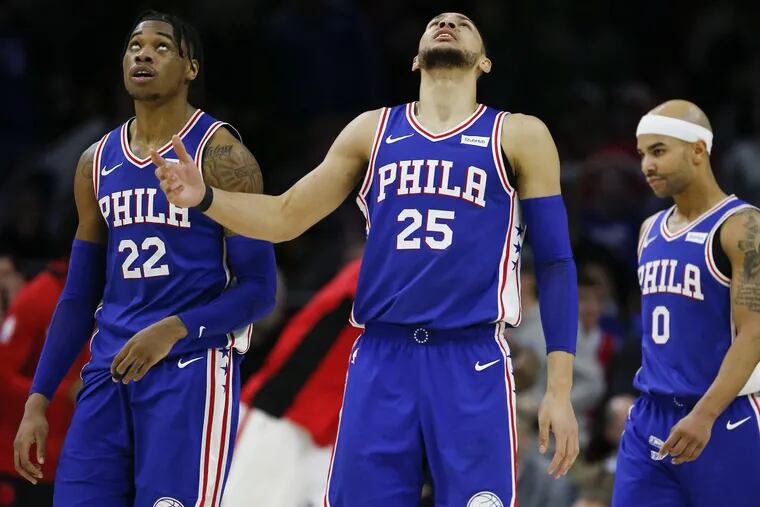 Sixers guard Ben Simmons looks up after committing a fourth-quarter offensive foul with teammates forward Richaun Holmes and guard Jerryd Bayless against the Toronto Raptors on Thursday, December 21, 2017 in Philadelphia.
