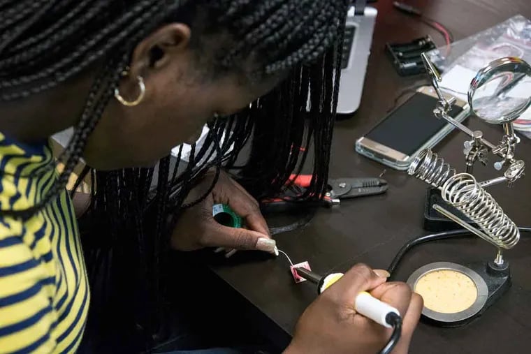 Onyea Cropper, 16, solders an accelerometer at Roxborough High School.