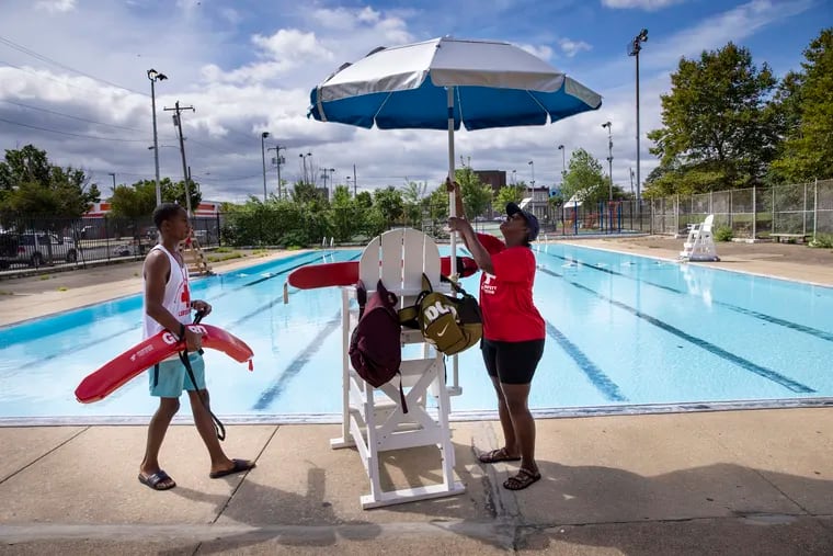 Lifeguard Jabrill David watches as Thelma Nesbitt sets up an umbrellas at Shepard Recreation Center in 2021.