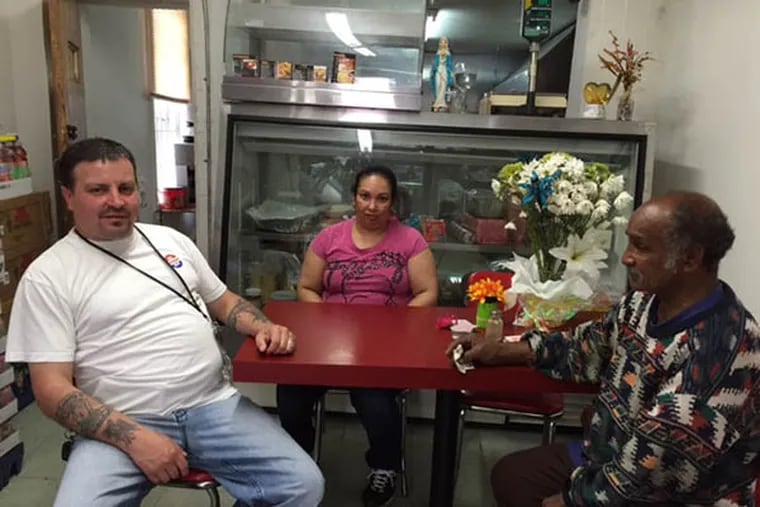 Committeeman John Lopez (left) sits with Annmarie Vargas, owner of the Sabor Latino corner store near 2nd and Indiana streets in Philadelphia. ( Photo by Mike Newall)