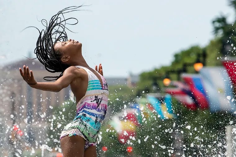 Amina Jones, 11, of Philadelphia, beats the heat at the Love Park fountain on Monday.
