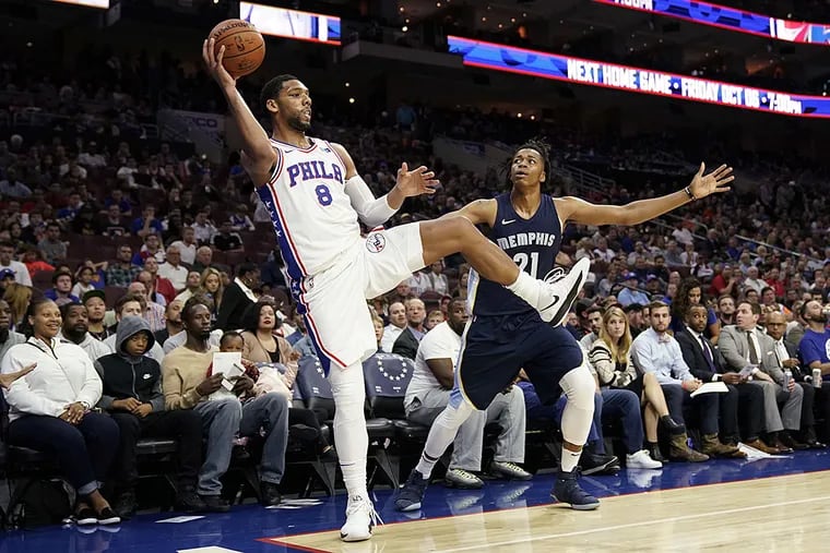 Philadelphia 76ers' Jahlil Okafor, left, saves a loose ball as Memphis Grizzlies' Deyonta Davis looks on during the first half of a preseason NBA basketball game, Wednesday, Oct. 4, 2017, in Philadelphia.