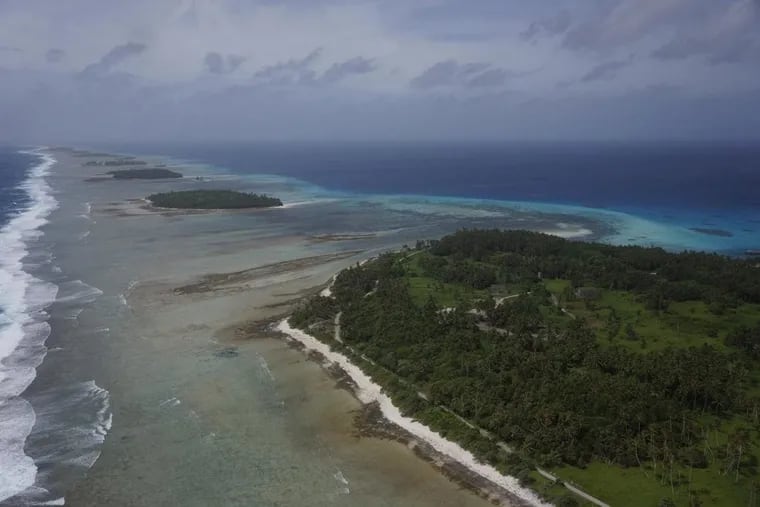 An aerial photograph of Kwajalein Atoll in the Marshall Islands shows its low-lying islands and coral reefs.
