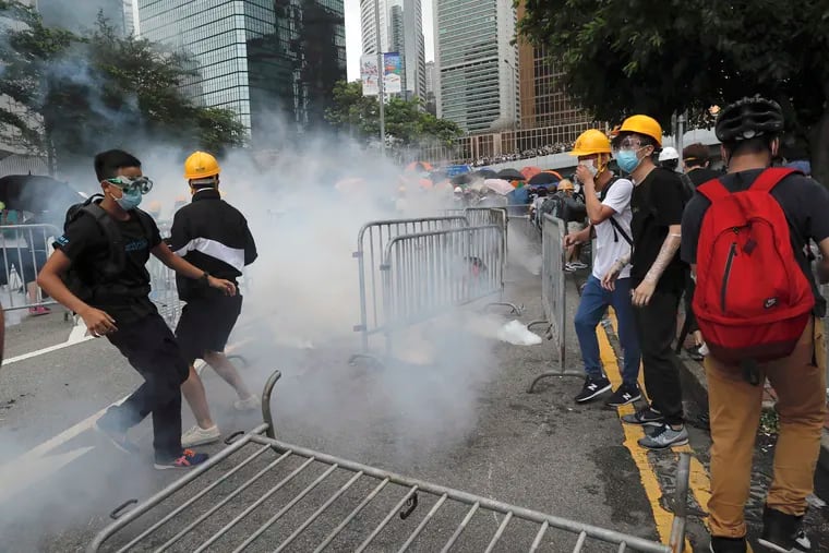 Protesters react to tear gas during a large protest near the Legislative Council in Hong Kong on Wednesday.