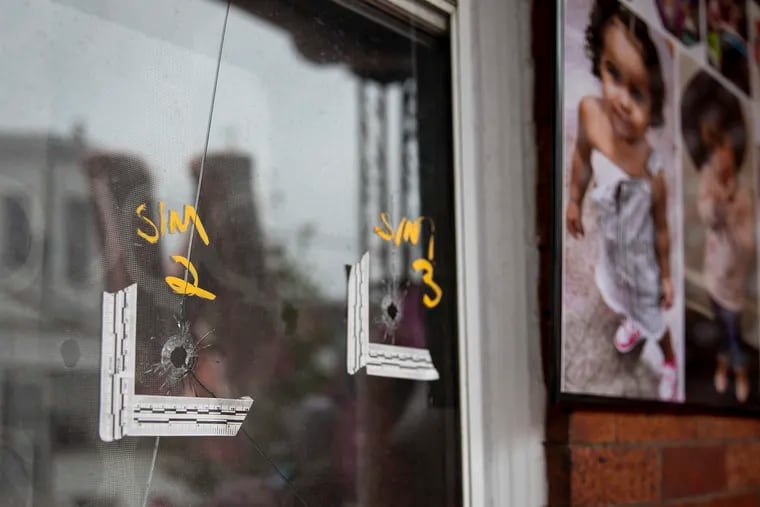 Bullet holes can be seen in the window of the house on Water Street where 2-year-old Nikolette Rivera was shot to death on Sunday. Loved ones hung photos of the child in her memory.