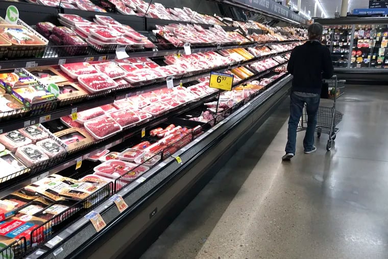 A shopper pushes his cart past a display of packaged meat in a grocery store in southeast Denver.