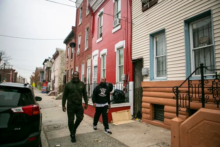 Robert Warner, right, and one of his mentees Jermaine McElveen, walks in north Philadelphia, the neighborhood they grew up in Philadelphia, PA on Friday, November 22, 2019. Robert Warner is a mentor to people in his neighborhood who are involved in gun violence.