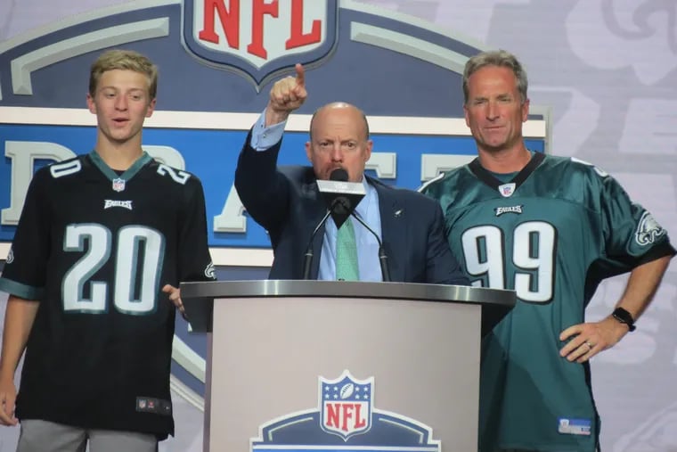 Jim Cramer, flanked by two Eagles season ticket holders announces the team's first fourth round pick at the draft.