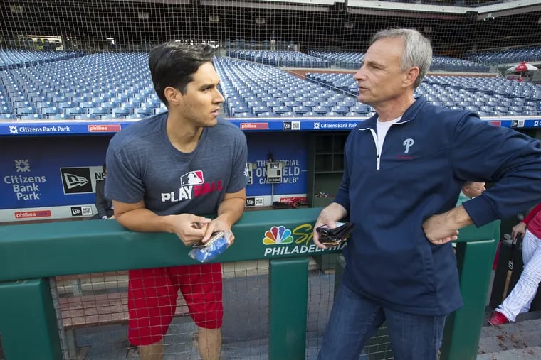 Diego Ettedgui (right), the Phillies translator, talks with Spanish-language radio broadcaster Bill Kulik before a game in September. The two are just a handful of Latin American figures who are crucial in helping the Phillies grow their Latino fan base.