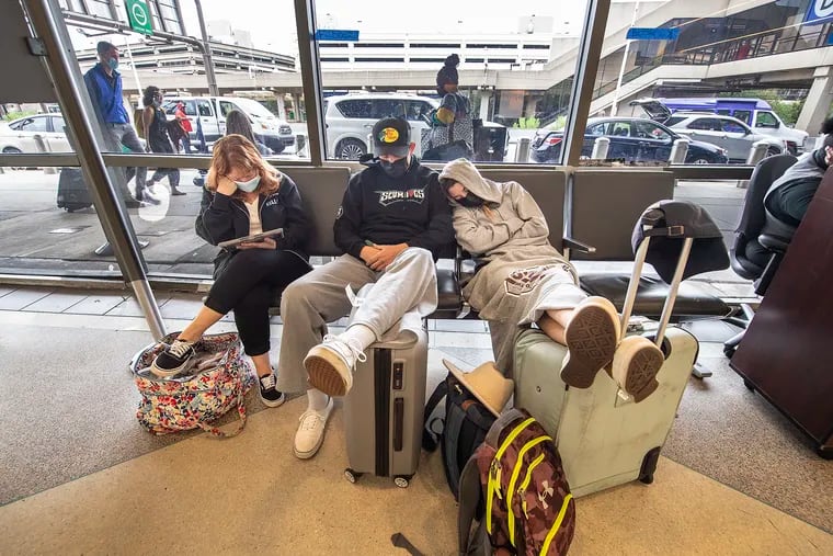 Stranded travelers sleep on the seats of the ticketing waiting area on Tuesday at Philadelphia International Airport. Their schedule flight to Los Angeles was delayed until Thursday, after Spirit suddenly canceled flights in Philadelphia-area and nationwide.