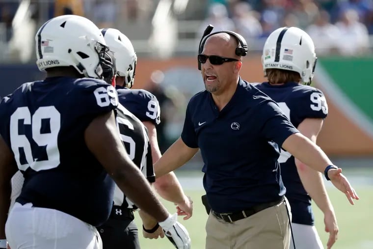 Penn State head coach James Franklin slaps hands with players during the Citrus Bowl against Kentucky.