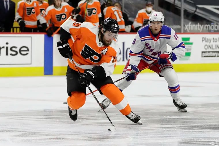 Flyers defenseman Ivan Provorov skates with the puck past New York Rangers center Ryan Strome.
