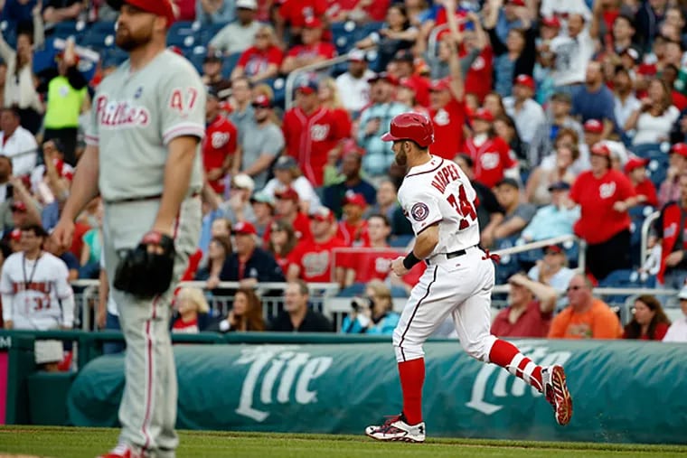 Washington Nationals' Bryce Harper, right, run the bases on his solo home run as Philadelphia Phillies starting pitcher Sean O'Sullivan (47) looks on during the second inning of a baseball game at Nationals Park, Friday, May 22, 2015, in Washington. (AP Photo/Alex Brandon)