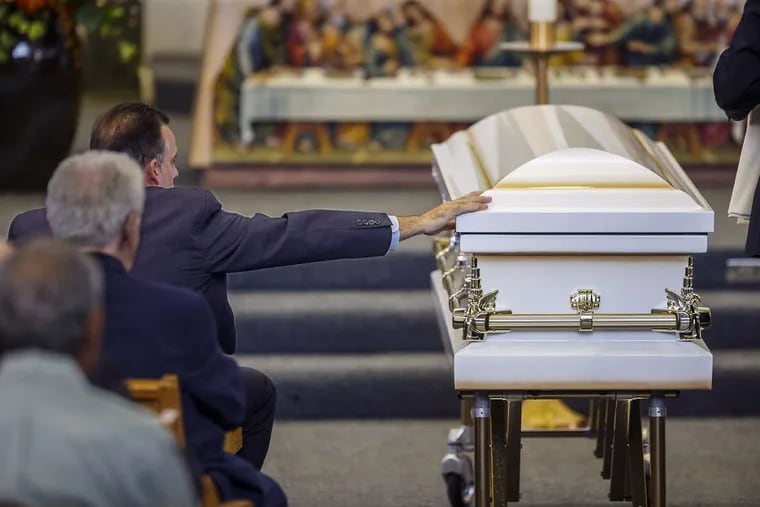 After the viewing was over, and the casket for 7 year-old Kayden Mancuso was closed, her stepfather, Brian Sherlock, left, reached over to touch her casket before the funeral service began at St. John the Evangelist Catholic Church in Morrisville, Bucks County, on Saturday, Aug. 11, 2018.